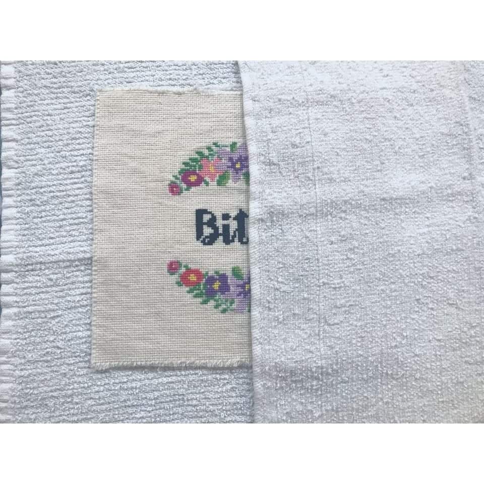Next, place a thin towel or light cloth on top of the finished, dry cross stitch project. This will prevent the iron from squishing the stitches while we iron on the front.