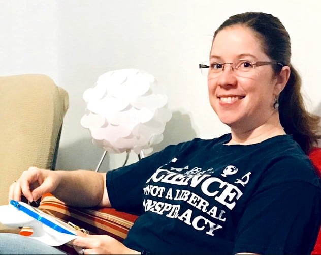 About photo showing Sarah cross stitching on a couch