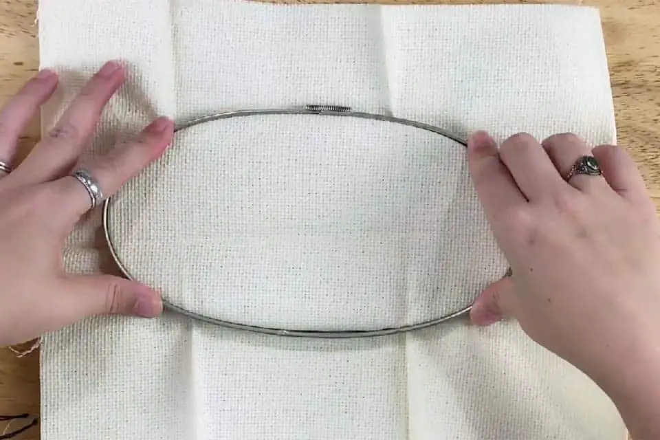 Push down outer ring of a vintage metal embroidery hoop over the inner ring with fabric in between.