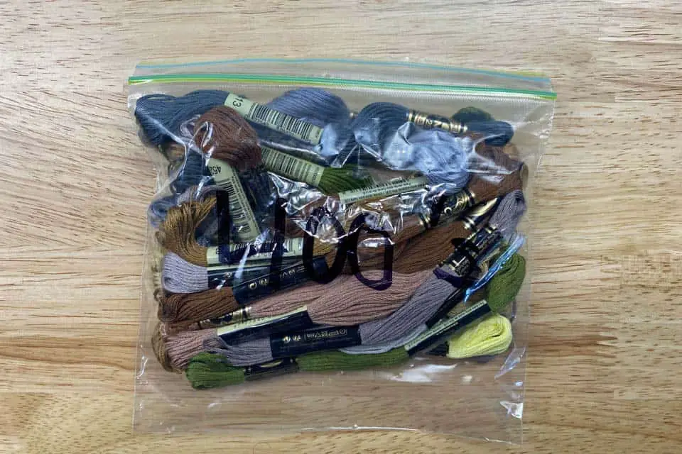 Sandwich baggie with "400's" written in sharpie on the front, holding a couple dozen random colored skeins of embroidery floss