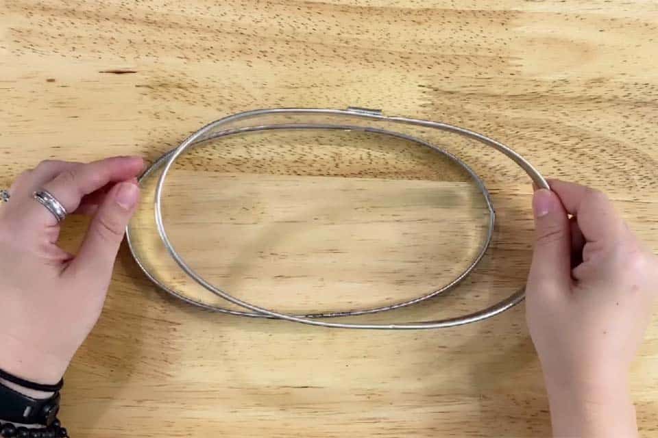Separating the inner and outer rings of a vintage metal embroidery hoop.
