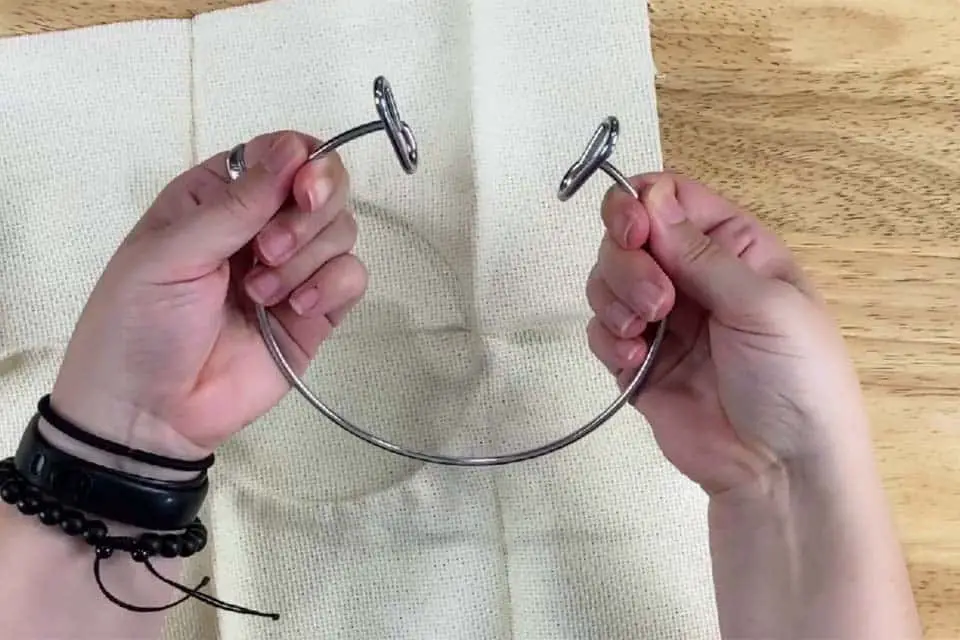 Stretching out the inner ring of a screw tension embroidery hoop by pulling apart the metal handles